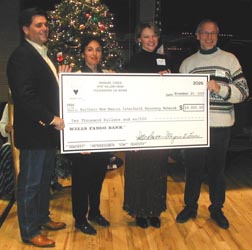 Shaklee Coordinator Elena Giacomin Dennis and Joe Dennis present a check to  the Interfaith Recovery Network to help NM fire victims.